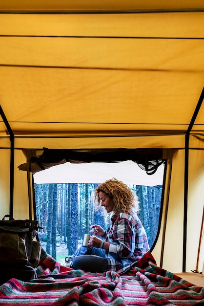 Foto mulher de viagem sentada na barraca automática e curtindo o ar livre pela janela com uma paisagem incrível melhor acordar durante uma viagem de aventura com sentimento conceito de natureza e ter liberdade nas férias