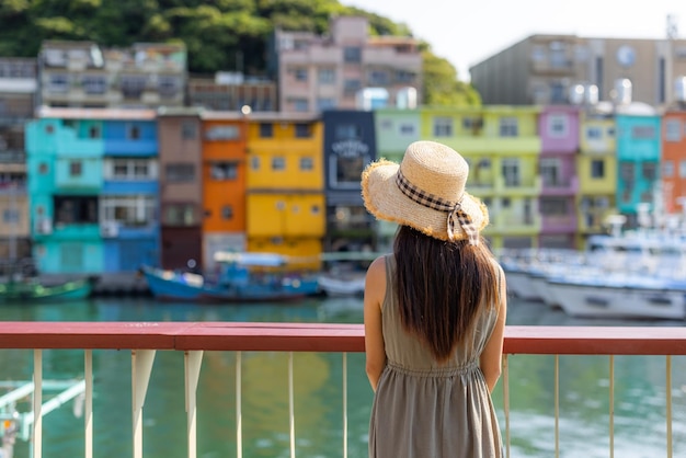 Foto mulher de viagem visita o colorido porto de pesca de zhengbin em keelung, em taiwan