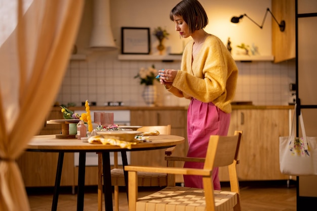 Mulher decora uma mesa de jantar em casa aconchegante