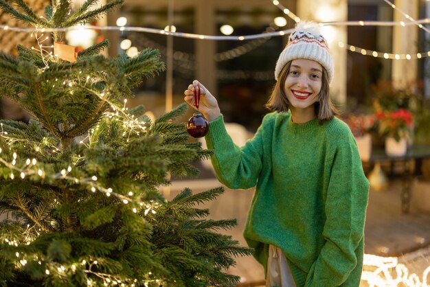 Mulher decorando árvore de natal no quintal