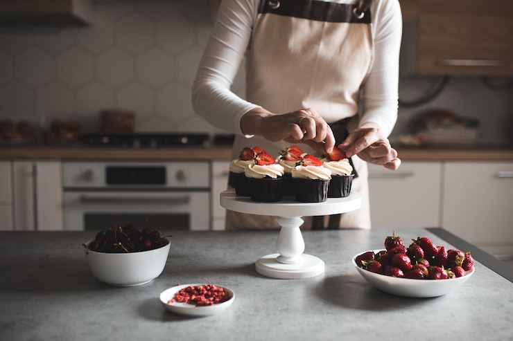 Foto mulher decorando cupcakes com frutas e cream cheese