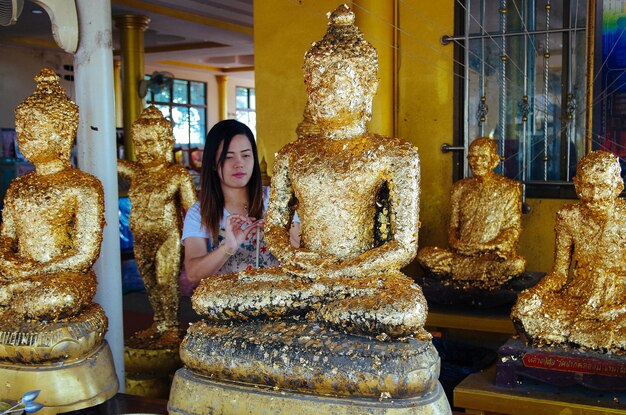 Foto mulher decorando estátua de buda