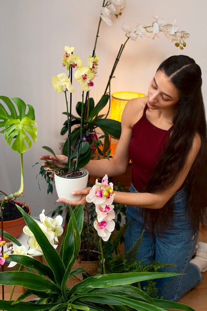 Mulher decorando sua casa com uma flor de orquídea