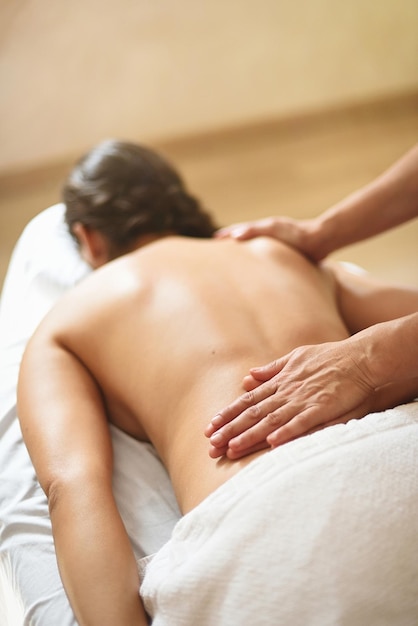 Mulher deitada de bruços recebendo energia reiki e sessão de massagem relaxante