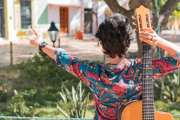 Foto mulher deitada de costas com violão no parque