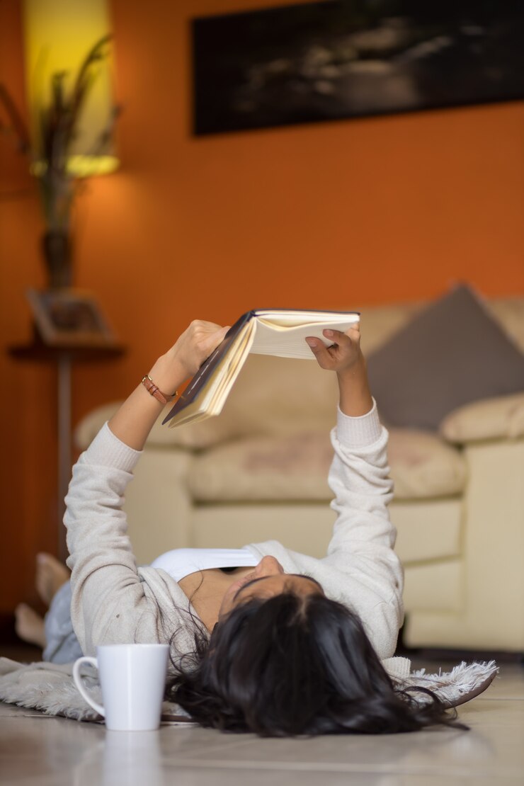 Mulher deitada lendo um livro