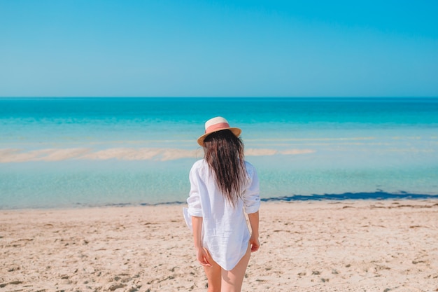 Mulher deitada na praia, aproveitando as férias de verão, olhando para o mar