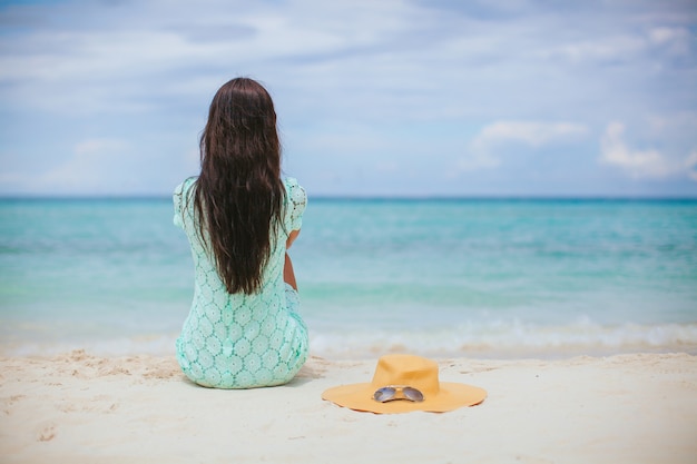 Mulher deitada na praia, aproveitando as férias de verão, olhando para o mar