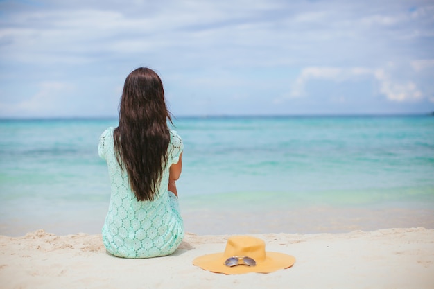 Mulher deitada na praia, aproveitando as férias de verão, olhando para o mar