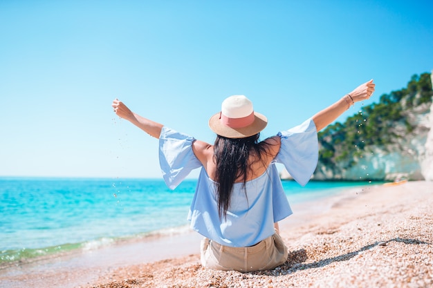 Mulher deitada na praia aproveitando as férias de verão, olhando para o mar