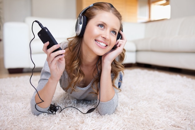 Mulher deitada na sala de estar desfrutando música