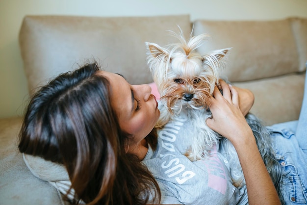 Mulher deitada no sofá com seu Yorkshire Terrier