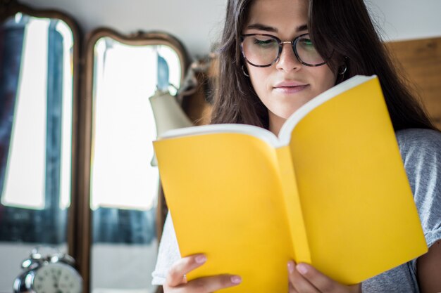 Mulher, deitando, cama, e, livro leitura