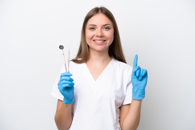 Mulher dentista segurando ferramentas isoladas no fundo branco apontando uma ótima ideia