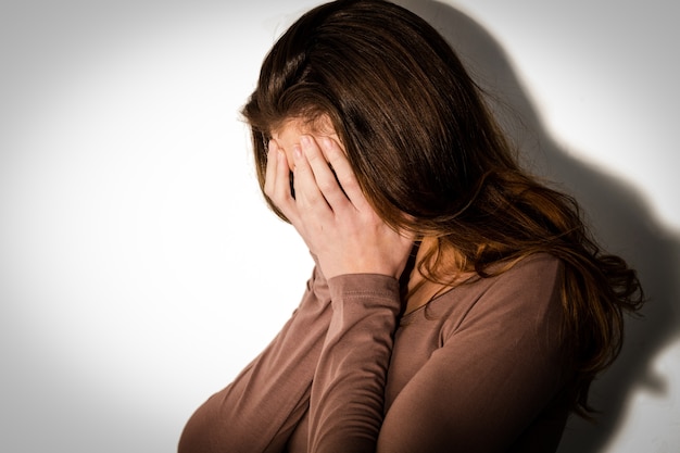 Mulher deprimida com a cabeça nas mãos