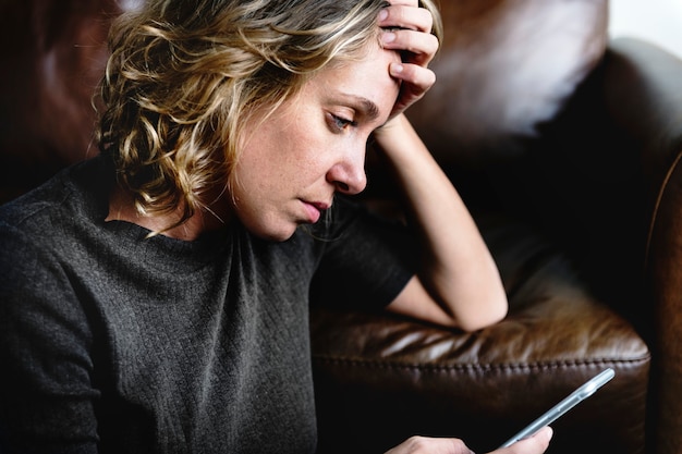 Mulher deprimida usando um telefone celular