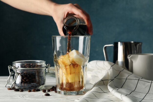 Mulher derrama um copo de café. composição com café gelado