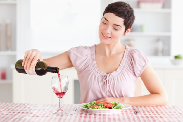 Mulher derramando vinho em um copo