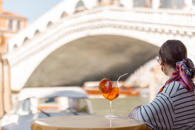 Mulher descansa no café ao ar livre no grande canal viajando em veneza