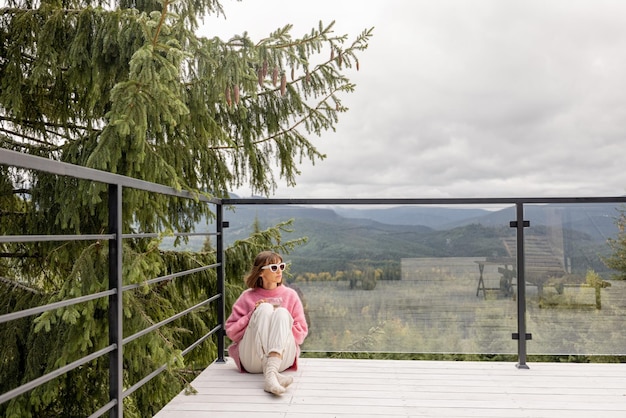 Mulher descansa no terraço nas montanhas