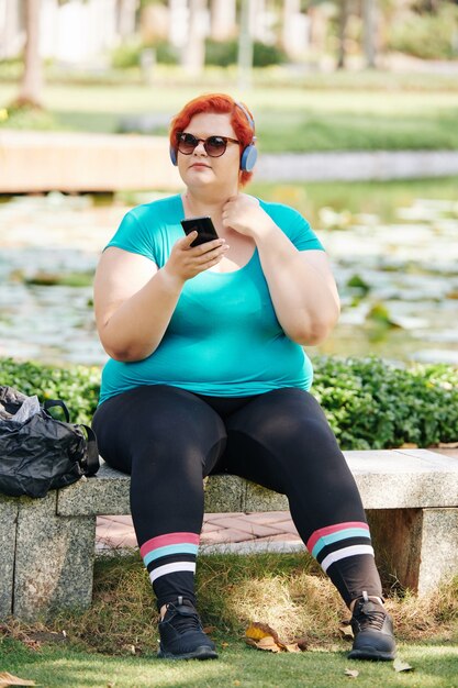 Mulher descansando em um banco no parque