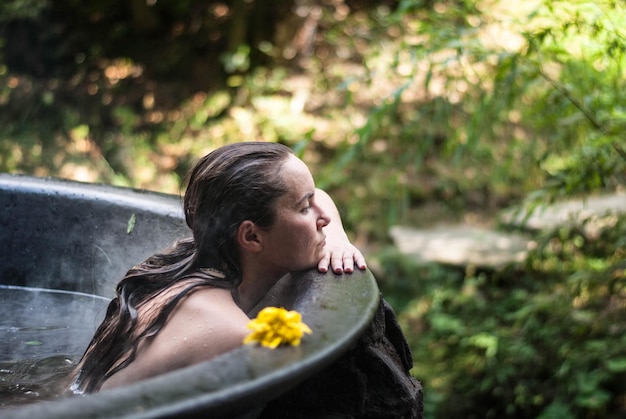 Mulher desfrutando de spa em banheiras de hidromassagem ao ar livre