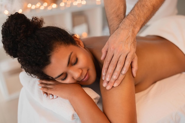 Mulher desfrutando de uma massagem no ombro no spa