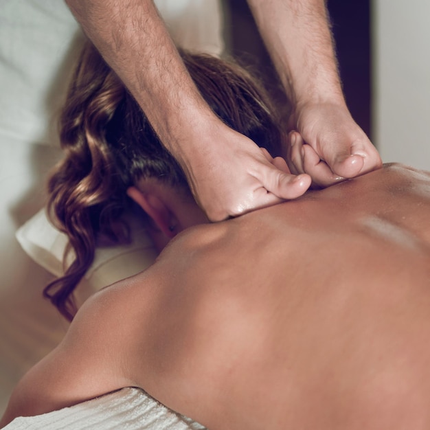 Mulher desfrutando de uma massagem relaxante nas costas no Centro de Cosmetologia Spa