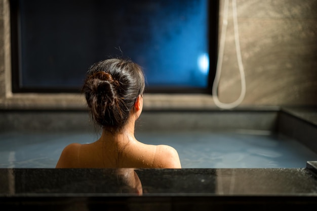 Mulher desfrutando do onsen na banheira no resort