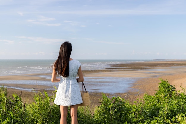 Mulher desfrutar da vista da praia de areia no topo