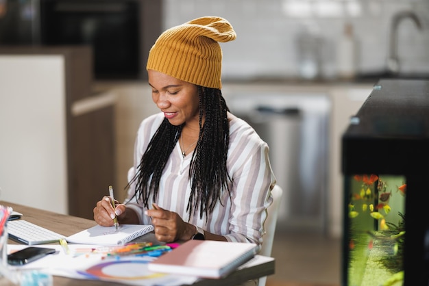 Mulher designer africana trabalhando em seu escritório em casa.