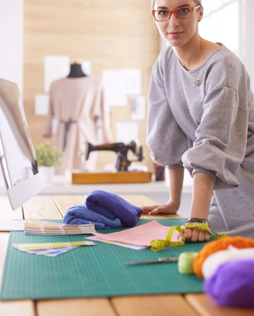 Mulher designer de moda trabalhando em seus projetos no estúdio