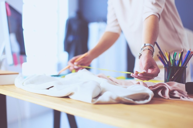 Mulher designer de moda trabalhando em seus projetos no estúdio