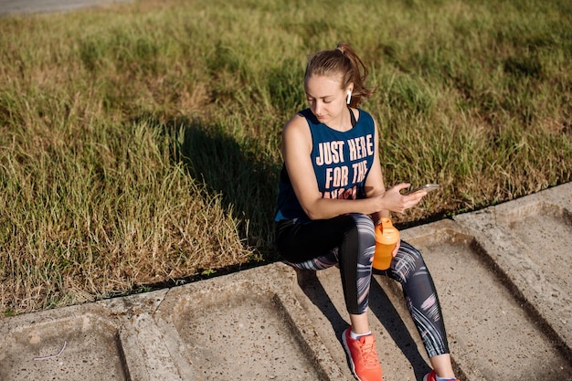 Mulher desportiva em roupas esportivas relaxando no cais no fundo da água