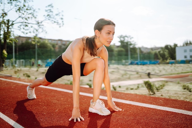 Mulher desportiva fazendo exercícios ao ar livre pela manhã Vida ativa Treinamento desportivo Estilo de vida saudável