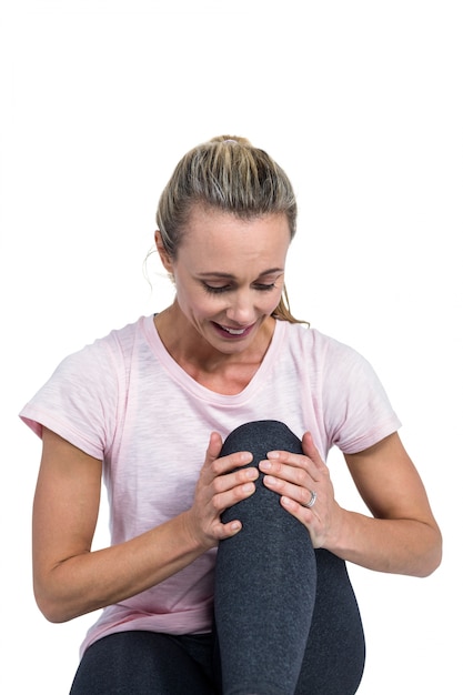 Mulher desportiva massageando joelho