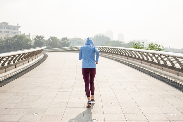 Mulher desportiva no Hoodie Running na ponte