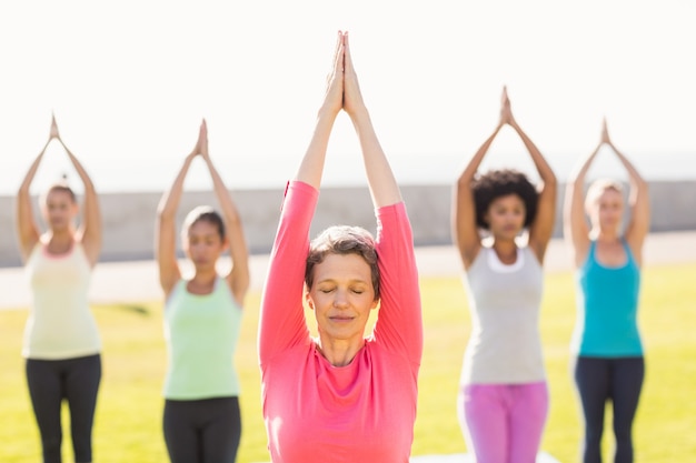 Mulher desportiva tranquila fazendo yoga na aula de ioga