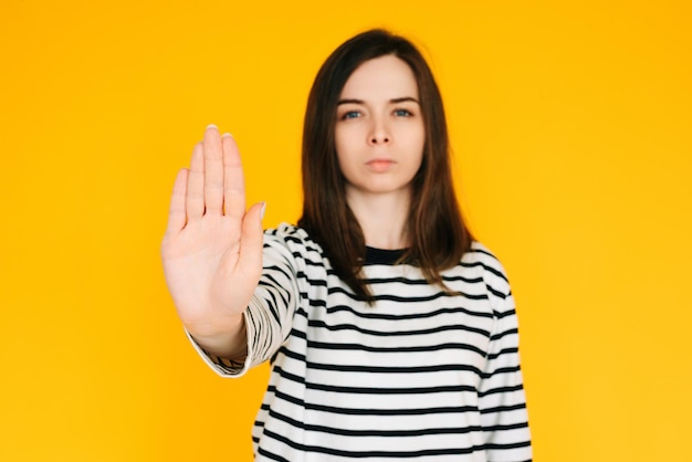 Mulher Determinada Fazendo Stand Serious Lady com Expressão Confiante Levantando a Mão em Gesto de 'Pare'