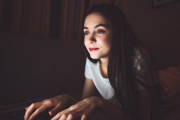 Mulher digitando em um teclado de laptop, conversando com amigos