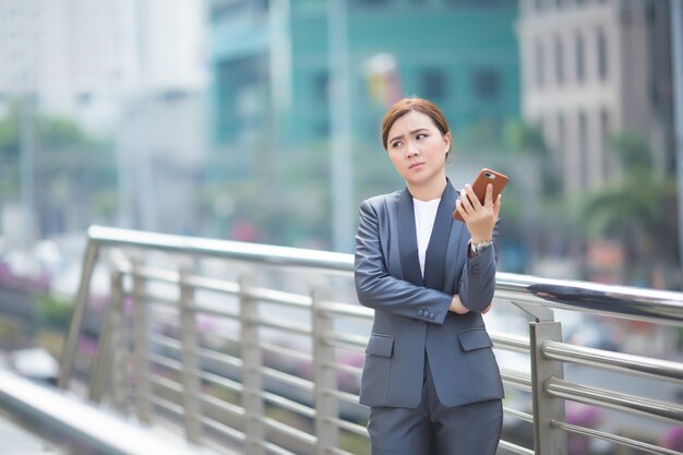 Mulher digitando no smartphone e fica triste