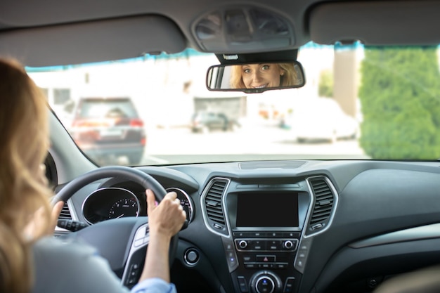 Mulher dirigindo carro olhando no espelho retrovisor