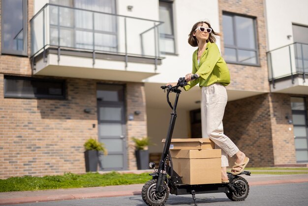 Mulher dirigindo scooter elétrico com pacotes de papelão