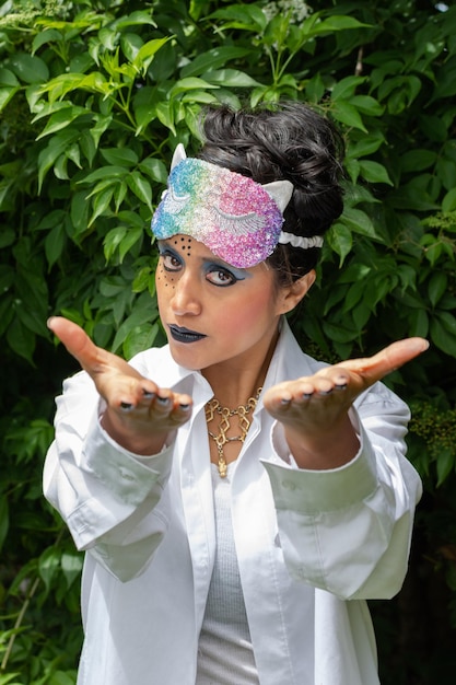 mulher disfarçada com maquiagem e máscara colorida sobre a cabeça em fundo natural