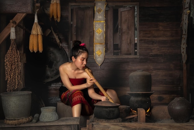 Foto mulher do campo cozinhando em uma cozinha de casa de madeira