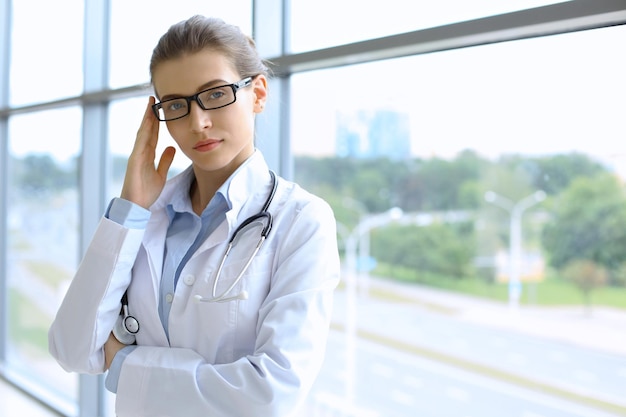 Mulher do médico sobre o fundo dos interiers da clínica