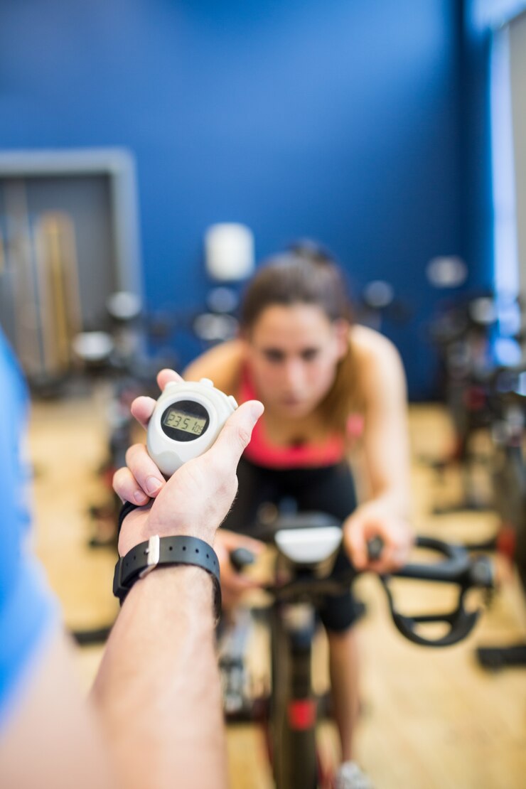Foto mulher do momento do instrutor na bicicleta de exercício