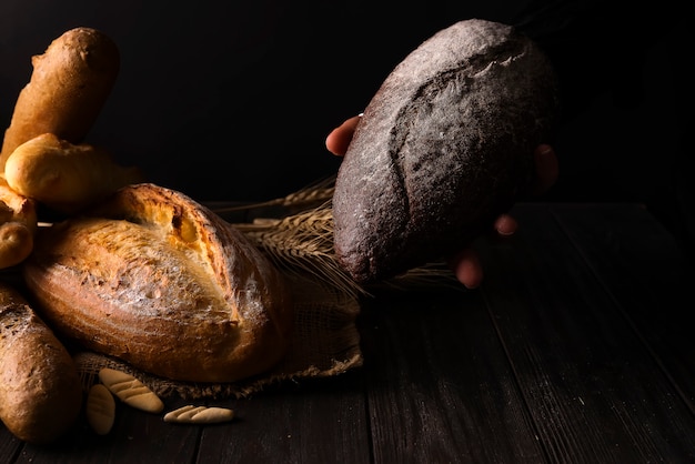 Mulher do padeiro que guarda o naco de pão orgânico rústico nas mãos - padaria rural.