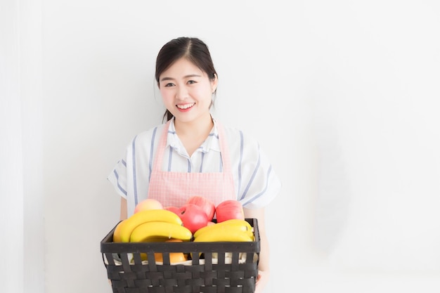 Mulher do sudeste asiático segurando uma cesta de frutas