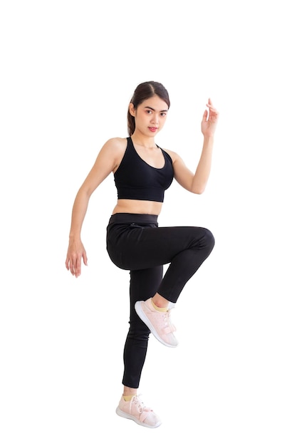 Mulher do sudeste asiático vestindo roupas de ginástica pretas fazendo uma pose de jogging com fundo branco